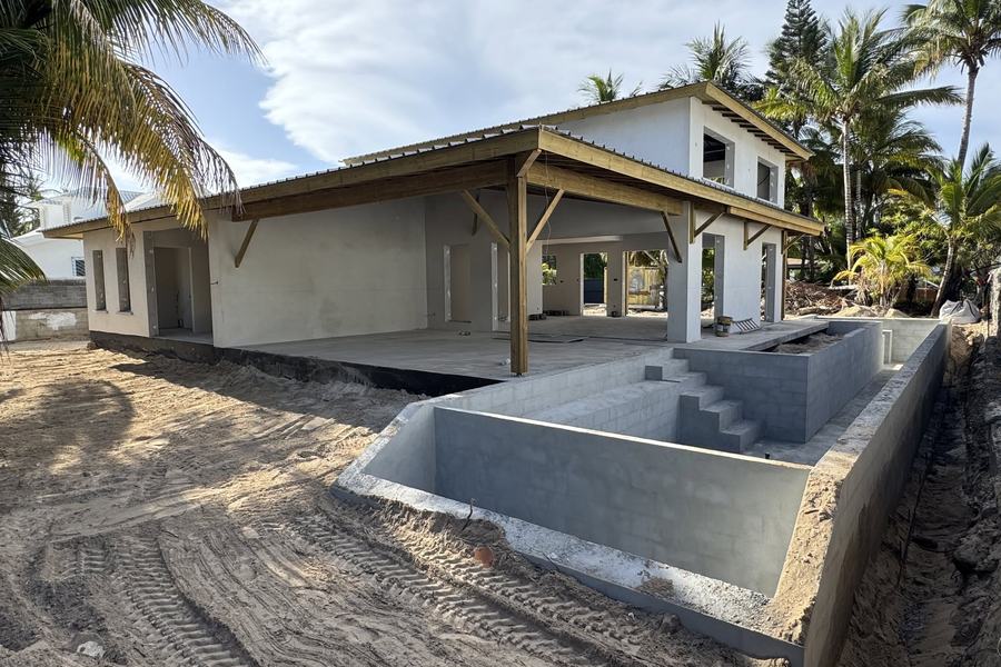 Maison en travaux avec charpente bois et couverture posées, bassin en cours