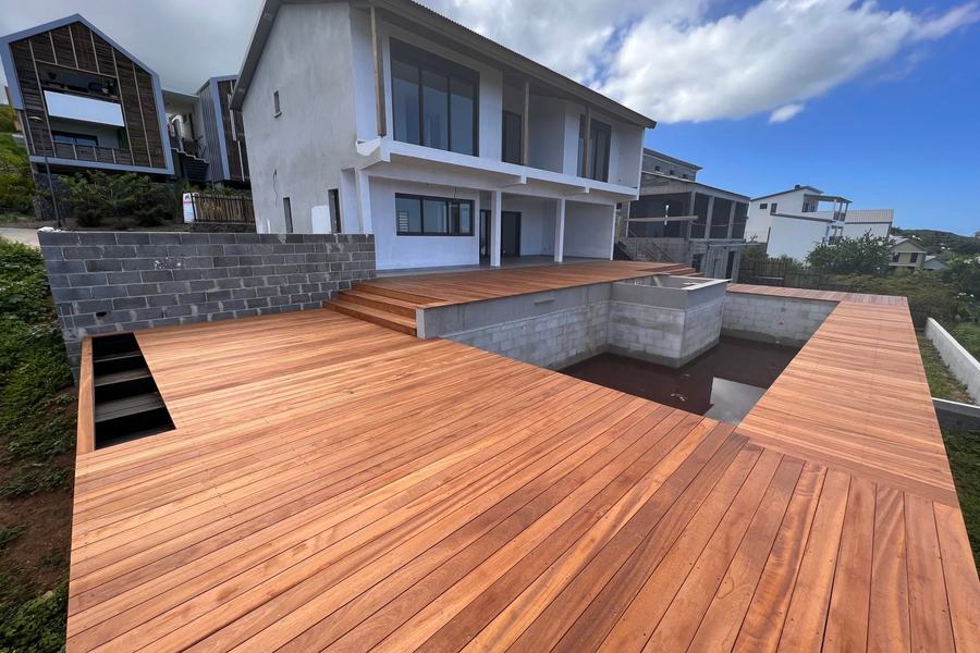 Grande terrasse en bois exotique posée autour d'un bassin en cours de réalisation