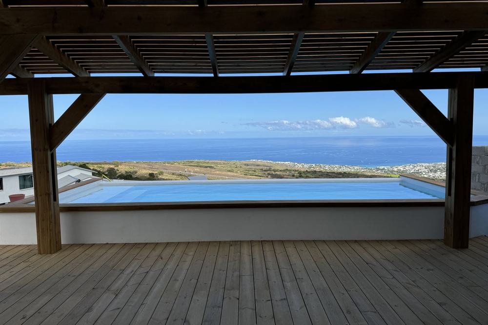 Piscine à débordement sous pergola bois avec vue sur l'océan