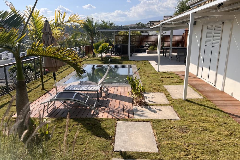 Jardin paysager avec piscine, terrasse bois et vue sur les hauts
