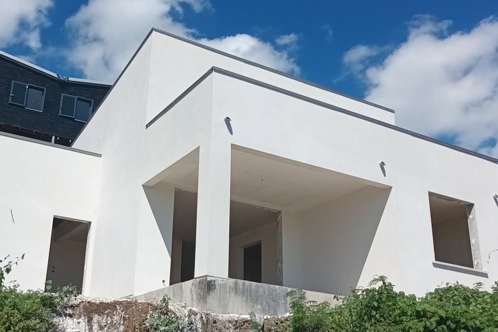 Maison contemporaine à toit plat, façade blanche et large avancée